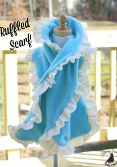 a blue and white ruffled scarf on a mannequin stand with text overlay