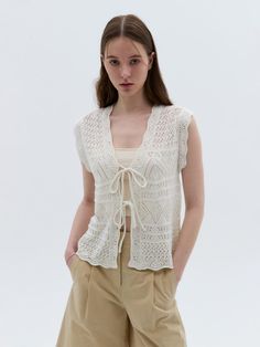 An open skashi-knit vest featuring a V-neck with self-tie closure. Ribbed trim.- Regular fit- Sleeveless- V-neck Chic Open Knit Vest, Elegant Crochet Top With Open Knit V-neck, V-neck Crochet Knit Top, Elegant Knit Summer Vest, Chic Open Knit Summer Vest, Elegant V-neck Open Knit Crochet Top, Elegant Summer Knit Sweater Vest, Chic White Sleeveless Cardigan, Knit V-neck Top For Daywear