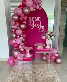 pink and silver balloons on display in front of a sign that says she said yes