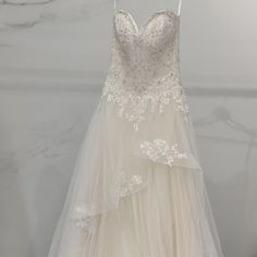 a wedding dress hanging on a hanger