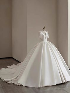 a white wedding dress on display in a room