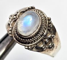 Blue moonstone tribal Bali Balinese style lotus flower vintage sterling silver ring. Good used condition with little to no signs of normal wear. Great vintage patina. Stamped 925 on the inside of the band. The sides of the band have mandala lotus flower petals. Acid tests positive for sterling silver. Ring measures size 9. Vintage Handmade Moonstone Rings, Luxury Silver Vintage Moonstone Ring, Luxury Vintage Silver Moonstone Ring, Vintage Moonstone Wedding Ring Stamped 925, Vintage Silver Moonstone Rings, Vintage Handmade Silver Moonstone Ring, Vintage Silver Handmade Moonstone Ring, Bohemian Untreated Round Moonstone Ring, Untreated Round Bohemian Moonstone Ring