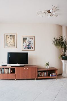 a living room filled with furniture and a flat screen tv on top of a wooden entertainment center