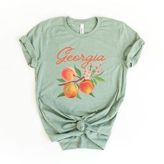 Elevate your casual wardrobe with the Simply Sage Market Women's Georgia Peach Flower Short Sleeve Graphic Tee. This charming top features a delightful floral design that adds a touch of femininity to any ensemble.

- Size: Small
- Color: Sage
- Material: Cotton blend (exact material details not specified)
- Gender: Female
- Age Group: Adult

Crafted for comfort and versatility, this tee pairs effortlessly with everything from biker shorts and jeans to skirts and dresses. Its true-to-size fit en Casual Peach T-shirt With Graphic Print, Trendy Peach T-shirt With Letter Print, Cute Peach T-shirt With Crew Neck, Trendy Peach Relaxed Fit T-shirt, Trendy Relaxed Fit Peach T-shirt, Peach Graphic Print Short Sleeve Top, Summer Peach T-shirt With Graphic Print, Casual Peach Tops With Letter Print, Peach Short Sleeve Top With Graphic Print