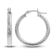 Dynamic 25mm hollow round tubes are embellished with distinctive diamond-cut patterns in these stylish women's hoop earrings. Fashioned in 14K white gold, the earrings secure in place with hinged backs. Small Hoop Engraved Earrings, Sterling Silver Hoop Jewelry With Diamond Cut, Luxury Round White Gold Hoop Earrings, Elegant Engraved Small Hoop Earrings, Engraved Small Hoop Jewelry, Modern Round Diamond-cut Huggie Earrings, Modern Round Diamond Cut Huggie Earrings, Luxury White Gold Hoop Earrings With Shiny Finish, Sterling Silver Hoop Earrings With Diamond Cut