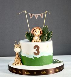 a birthday cake with a giraffe and monkey on top