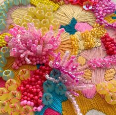 a close up of many different types of beads on a piece of cloth with beading