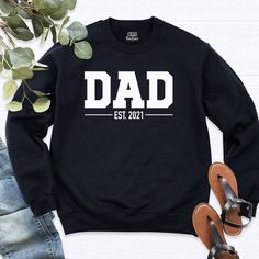 Dad Est Sweatshirt, Fathers Day Sweatshirt, New Dad Hoodie, birthday dad Sweatshirt, personalized dada shirt, shirts for dad, daddy est tee. If you are looking for short sleeve shirt, click the link https://www.etsy.com/listing/839779352/favorite-daughter-shirt-i-love-my   Welcome to our store!  -We specialize in funny, customizable apparel shirts in different colors and styles printed on ultra-soft, super comfortable, and breathable material.  -Solid colors 50/50 Preshrunk Cotton/Polyester -We Personalized Black Crew Neck Sweatshirt, Personalized Crew Neck Tops For Father's Day, Customizable Long Sleeve Sweatshirt For Father's Day, Customizable Long Sleeve T-shirt For Father's Day, Casual Black Sweatshirt For Birthday, Family Matching Crew Neck Sweatshirt For Father's Day, Black Casual Sweatshirt, Father's Day Casual Sweatshirt Gift, Casual Father's Day Gift Sweatshirt