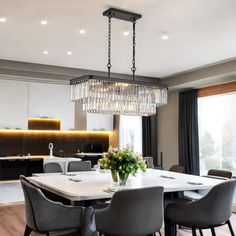 a dining room table with chairs and a chandelier hanging from it's ceiling