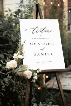 a welcome sign with flowers and greenery on it