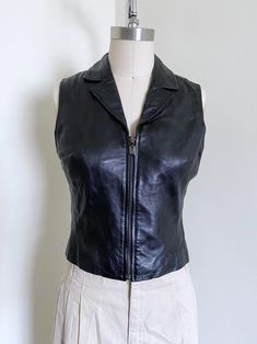 Incredible cropped leather vest. Features: a fitted style, zip closure, knit material, leather material, and a timeless style. Era: 90's Label: None Size Marked: None Estimated Size: S Material: Leather, Knit Blend with stretch Condition: Excellent Measurements: Measured Flat Chest: 16 1/2"-17 1/2"stretch Waist: 14 1/2"-15 1/2"stretch Length: 18" Measured flat, photographed on a size 6 form http://www.etsy.com/shop/wemovevintage All measurements are taken with the garment lying flat. Please see our policies for our point of measure :) Http://www.etsy.com/shop/wemovevintage/policy Please let us know if you have any questions! WEMOVEVINTAGE 6th Form, Black Leather Vest, Fitted Style, Vest Outfits, Leather Vest, Knitting Materials, Flat Chest, Womens Vest, Leather Material