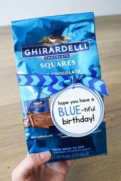 someone is holding up a bag of blue - ful birthday chocolate from ghirardbell