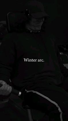 a man sitting in a chair with the word winter arc written on his shirt over his face