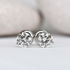 These timeless and elegant stud earrings are a true staple in any girl's jewelry box! 3 prong "cocktail style" setting Set with stunning lab grown diamonds Choose your center lab grown diamond: Better: an eye-clean diamond that's very slightly warm in color (SI+ clarity, GHI color) Best: an impeccable diamond, that's completely colorless (VS+ clarity, DEF color) Earrings weighing 1.00ct (total per pair) or above are crafted with threaded screw back posts, to ensure you never loose them. You're w Minimalist Solitaire Diamond Earrings, Minimalist Solitaire Cubic Zirconia Diamond Earrings, Elegant Round Cut Diamond Earrings With Tension Setting, Minimalist Cubic Zirconia Solitaire Diamond Earrings, Timeless Tension Setting Earrings For Anniversary, Timeless Earrings With Tension Setting For Anniversary, Minimalist Solitaire Diamond Earrings In White Gold, Minimalist Solitaire Sterling Silver Diamond Earrings, Classic White Gold Diamond Earrings With Tension Setting