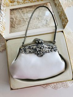 A gorgeous Erickson Beamon white satin evening bag, boxed, used, in great vintage condition. Couple of tiniest dots on the surface. Could be removed from cleaning.  In antique gold hardware, crystal pastes and faux pearls decorating frames.  One pearl missing .  This sweet little evening bag is just right for your fabulous party , Very romantic and super glamorous, prefect for wedding, party.  Measurements: 14x 9cm. Luxury Victorian Silver Bags, White Clutch Evening Bag, White Handheld Evening Bag For Formal Occasions, Vintage Party Clutch With Pearl Handle, White Handheld Clutch For Evening, White Handheld Evening Clutch, Formal White Clutch Evening Bag, White Handheld Evening Bag, Rectangular Satin Wedding Bag