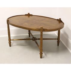 an oval wooden table sitting on top of a white floor