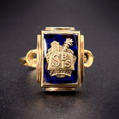 The tradition of class rings originated with the class of 1835 at the United States Military Academy at West Point. From there, the practice of a dated ring signifying ones alma mater became a popular fashion, worn as a symbol of pride and accomplishment. This piece has been converted to a ring from a school pin. The detailed face shows a cityscape in the background with a torch and open book bearing the initials S B S. Riveted to a cobalt blue spinel stone with a closed back, it has a wonderful vintage graphic feel, perfect for bookworms everywhere! Details (approximate) Size: 7.5 Weight: 5.8 grams Materials: Gold, Blue Spinel Metal: 10K yellow gold, 14K yellow gold Marks: Shank: Stamped KC & S; 9, 375, Maker's mark, 14K. Ring back: 10K, M.A.A. Condition: Very good vintage condition This Antique 14k Gold Hallmarked Enamel Ring, Antique Engraved Enamel Ring For Anniversary, Heirloom 14k Gold Signet Ring For Commemoration, 14k Gold Heirloom Signet Ring For Commemoration, Heirloom 14k Gold Engraved Ring For Commemoration, Classic 14k Gold Engraved Ring For Commemoration, Classic Engraved Enamel Ring For Formal Occasions, Antique Yellow Gold Rings For Commemoration, 14k Gold Engraved Ring With Hallmarks For Commemoration