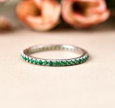 a close up of a ring on a table with flowers in the backgroud