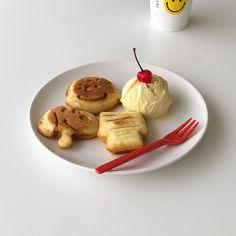 a white plate topped with cookies and ice cream next to a cup of coffee on a table