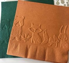 two brown paper napkins with animals on them