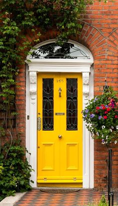 a yellow front door with two flower boxes on either side and an arch above it