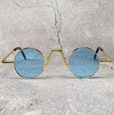 Rare and unique this is a must have 1910s style sunglasses for your collection. Intricate design with amazing details throughout the entire frame. Stable gold metallic frame with small light blue round lenses. Always an excellent choice for summer vacation, beach party or any other occasion, very good quality. New old stock. Great condition. Never worn. UV Protection. NOS Deadstock Made in Europe FIT INFORMATION 35 mm Eye Size 20 mm Bridge 140 mm Temple/Arm Width 5 Inches Height 1 1/4 Inches Blue Steampunk, Victorian Vampire, Steampunk Sunglasses, Small Light, Dracula, Beach Party, Eyewear Sunglasses, Fashion Sunglasses, Cyberpunk