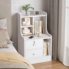 a white book shelf next to a bed