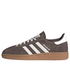 The adidas Handball Spezial Shoes blend classic design with modern flair. Originally crafted for indoor handball in 1979, these low-top sneakers have seamlessly transitioned to everyday wear. The premium suede upper, accented with soft leather details, exudes sophistication. The distinctive serrated 3-stripes and brown rubber sole add a touch of sportiness. Whether you’re hitting the streets or embracing casual style, the Handball Spezial Shoes are a timeless choice. Available in an Earth Strata Adidas Shoes Brown, Everyday Shoes Womens Casual, Soft Autumn Shoes, Handball Spezial Shoes, Spezials Adidas, Adidas Samba Classic, Spezial Shoes, Brown Adidas, Adidas Brown