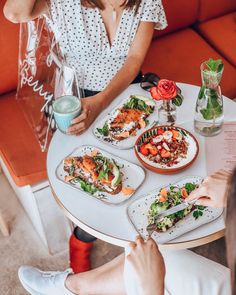 two women sitting at a table with plates of food