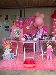 there is a pink birthday party set up with balloons and decorations on the wall,