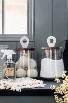 three glass containers filled with different types of items on top of a black countertop