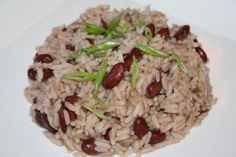 rice and beans on a white plate with some green garnish in the middle