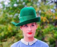 "DESCRIPTION * Vintage mod hat from 1950s-1960s * cloche style: close-fitting high round crown, designed to be worn low on the forehead, with slight brim, upturned on one side * made with wool material in Christmas green color * hatband is wrapped with a thick grosgrain ribbon embellished with a fold on the side * label reads \"Peachfelt, 100% Wool, Henry Pollak, Inc, New York\" Union made tag is illegible. CONDITION * the hat is in good vintage condition with a tiny hole the brim as shown in th Retro Fitted Brimmed Felt Hat, Retro Fitted Fedora Felt Hat, Retro Fitted Cloche Hat With Short Brim, Retro Fitted Brimmed Top Hat, Retro Fitted Top Hat With Wide Brim, Retro Fitted Top Hat With Short Brim, Retro Fitted Top Hat With Brim, Fitted Vintage Cloche Hat For Vintage Events, Classic Fitted Cloche Cap