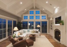 a living room filled with furniture and a fire place in front of a large window