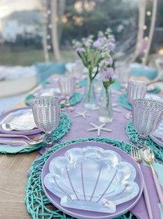 the table is set with purple and blue plates