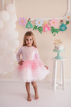 Little girls will love this ballerina dress with sequined fabric on the inside, lycra lining on the inside and a self-contained body. There is a zipper at the back. It is pink and white in color. Pink Fitted Fairy Dress For Parties, Fitted Pink Fairy Dress For Party, Long Sleeve Princess Fairy Dress For Party, Pink Tulle Fairy Dress For Party, Princess Style Sequined Tutu Dress For Dress-up, Party Ballet Tutu Dress With Ruffles, Princess Style Fitted Sequin Dress In Glitter Tulle, Fitted Fairy Dress For Party, Princess Style Sequin Party Dress