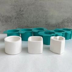 several white and blue vases sitting next to each other on top of a table