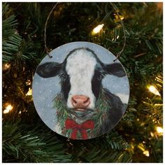 a christmas ornament with a cow wearing a red bow