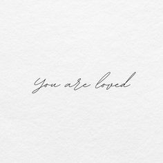 the words you are loved written in cursive handwriting on white paper with black ink