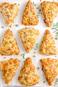 nine cheesy pastries arranged on top of a sheet of white parchment paper