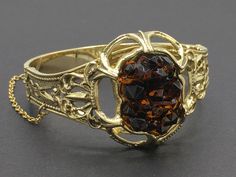 "Beautiful Art Nouveau style bracelet by Whiting and Davis with a contrasting geode style rhinestone centerpiece. I love the contrast that this element provides. Closes with a push in clasp and safety chain that is secured with a safety chain. SIZE/CONDITION: Like new condition. Fits a small to small/medium wrist size. (Mine is 6.25\" around and is about the largest that would fit.) About 1.5\" from top to bottom in the front. LINKS: Looking for a VINTAGE BRACELET, and this isn't the one? Click Collectible Costume Jewelry Bangle, Vintage Gemstone Bangle For Formal Occasions, Vintage Gold Bangle With Gemstone, Vintage Gemstone Cuff Bracelet Bangle, Vintage Gemstone Cuff Bracelet, Formal Faceted Bangle Jewelry, Gold Vintage Bracelet, Vintage Gold Bracelet, Safety Chain