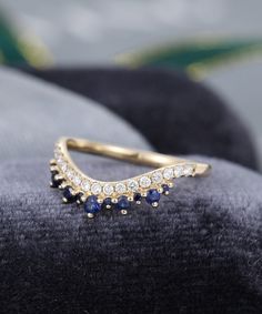 a diamond and sapphire ring on a velvet cushion