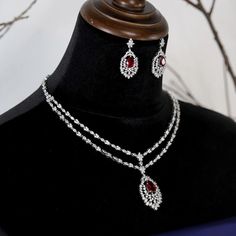 Glamourous and exquisitely elegant 14k white gold plated ruby red and Crystal wedding necklace set, elegant V drop design Perfect for that elegant evening, weddings, and any other special occasion. Every piece is made to perfection, we only use the finest CZ diamond like cubic zirconia for that dazzling and dramatic look and always at a fraction of the price of any bridal boutique. Measures approximately 16"L - fold-over and locked clasp 1 1/2" drop pierced back earring 14K White gold electropla Evening Weddings, Crystal Wedding Necklace, Wedding Necklace Set, Crystal Statement Necklace, Drop Design, Wedding Bridal Jewellery, Crystal Wedding, Red Crystals, Cz Diamond