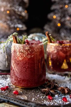 two glasses filled with red liquid and topped with cinnamon, star anise sprinkles