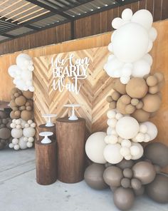 an assortment of balloons and cake stands in front of a wood paneled wall that reads, we are the beardy man