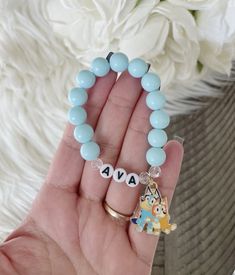 "Personalized blue heeler charm bracelet perfect for any Bluey lover! Double strung for extra durability. Made with 10mm acrylic beads This listing is for one bracelet.  SIZE:  5.5\"       (approx. 2-5 years) 6\"          (approx. 5-8 years) 6.5\"       (approx. teen/small adult) 7\"          (approx. adult) 7.5\"       (approx. adult) Sizing chart provided is a guide to ordering a size. Please understand these measurements are only estimates. Measure the wrist with a flexible measuring tape for a more custom fit.  ( I recommend adding a half an inch to allow room for movement) Add your custom size to the notes to seller section when checking out! CARE: Please be mindful not to overstretch bracelets. Excessive force or pulling may result in breakage. Keep dry as water may cause discolorati Bluey Diy, Kids Bead Bracelet, Bracelets Kids, Bluey And Bingo, Blue Heeler, Measuring Tape, Personalised Kids, Acrylic Beads, Sizing Chart