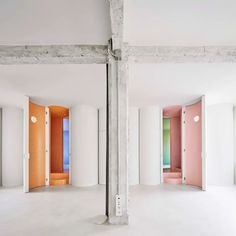 an empty room with multiple colored doors in it