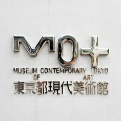 the museum contemporary tokyo sign is displayed in english and chinese writing on a white wall