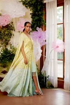 Feel the summer breeze in this flowy Zinnia Kaftan. It is beautifully adorned with floral motif embroidery all over, highlighted with golden and aqua-hued sequence work. To give it that elegant look, an ombre hue of aqua is added at the bottom of the Cape. To match the cape, A fully sequenced dress balances the sophistication and adds a modern touch to the outfit. This summer festive season, this flowy attire with pristine hues is the perfect choice to go with. Cape-style kaftan is covered with Kaftan Set, Motif Embroidery, Cape Style, Sequence Work, Summer Breeze, Bead Stringing, V Cuts, Elegant Look, Festive Season