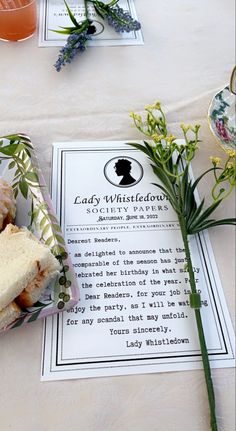 sandwiches and flowers on a table with an old lady's whitehouse menu in the background